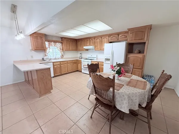 a room with stainless steel appliances kitchen island granite countertop a sink cabinets and wooden floor