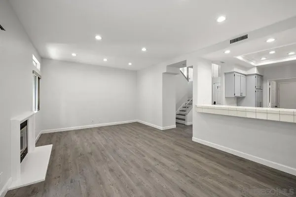 a view of a kitchen with refrigerator and wooden floor