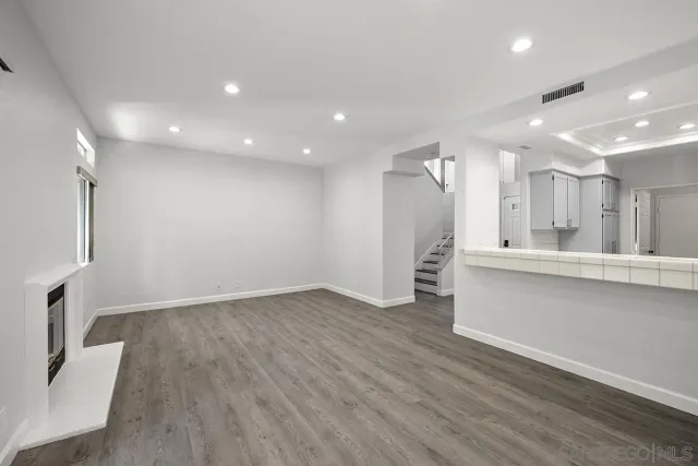 a view of a kitchen with refrigerator and wooden floor