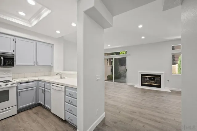 a kitchen with white cabinets and sink