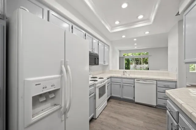 a kitchen with white cabinets and white appliances