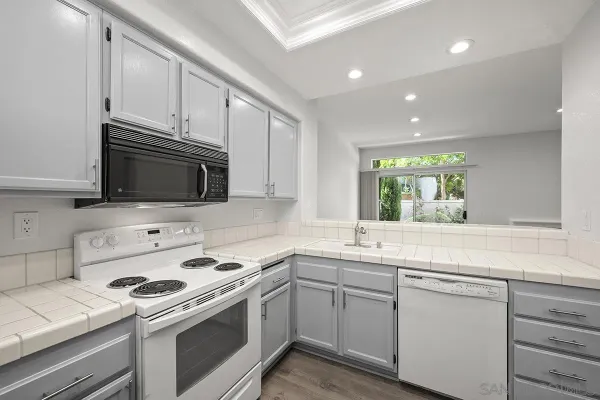 a kitchen with stainless steel appliances white cabinets and a sink