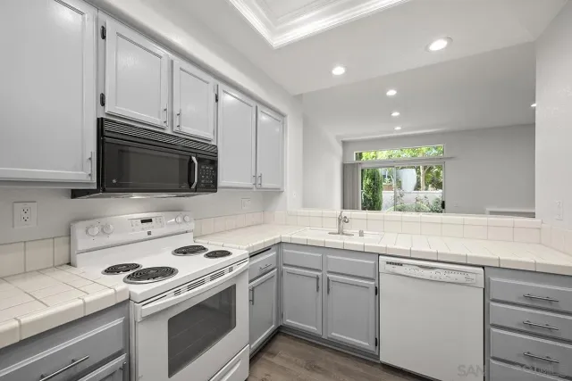 a kitchen with stainless steel appliances white cabinets and a sink