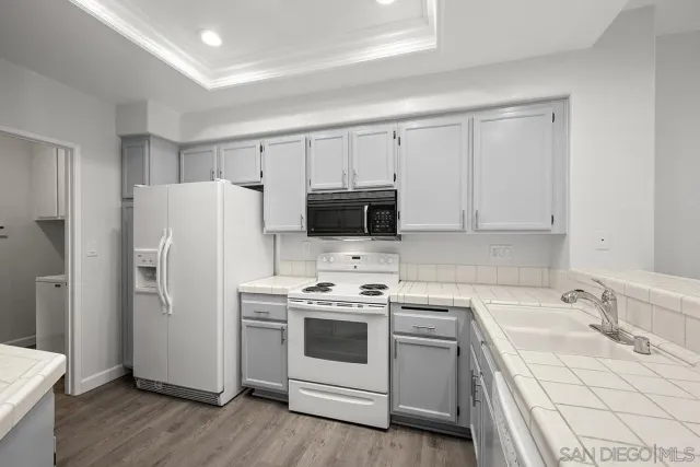 a kitchen with a sink a stove a refrigerator and cabinets