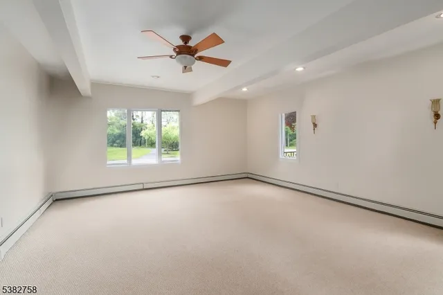 an empty room with windows and fan
