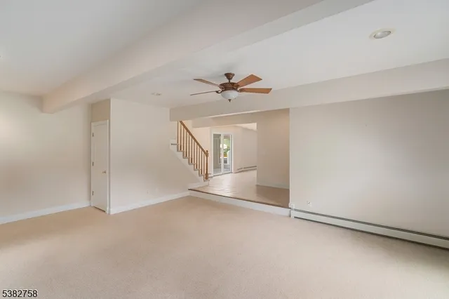a view of an empty room with a ceiling fan
