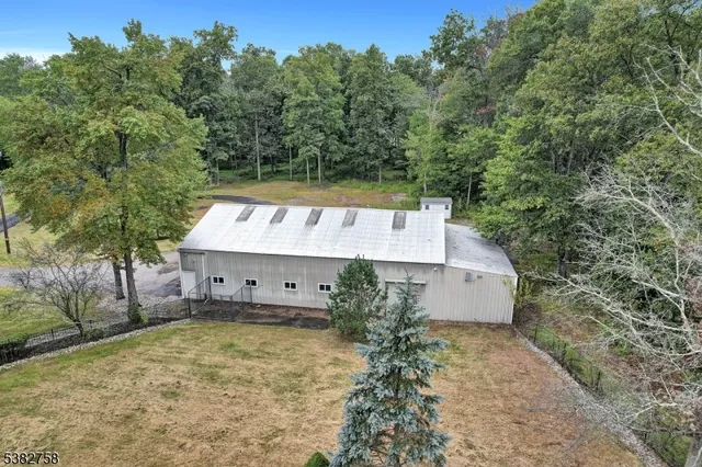 a view of a house with a yard and large tree