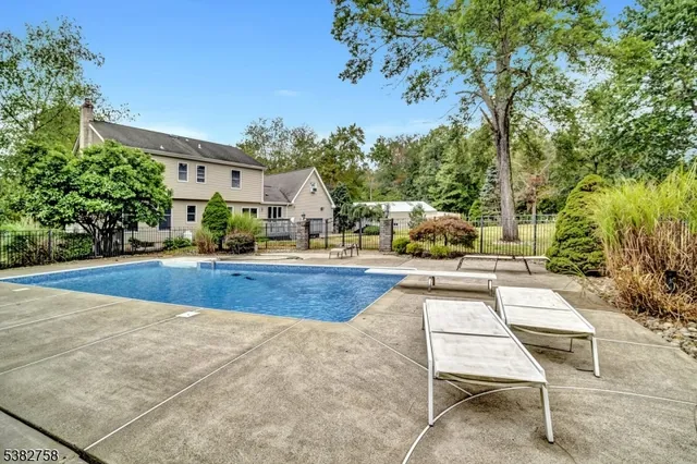 a view of yard with swimming pool and seating space