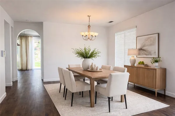 a dining room with furniture potted plants and wooden floor