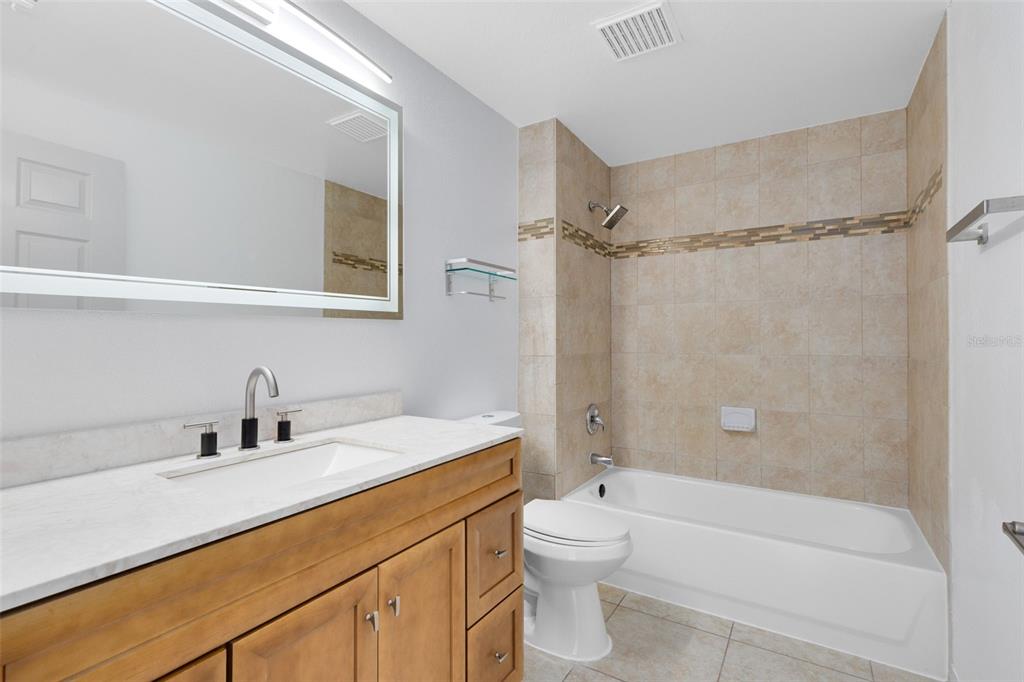 3315 Parkchester Square Boulevard, Unit 102 Orlando, FL 32835 - Photo 20 of 37 a bathroom with a sink a toilet and shower