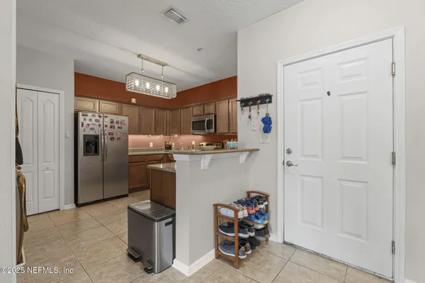 a kitchen with refrigerator and chairs