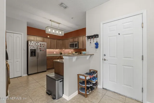 a kitchen with refrigerator and chairs