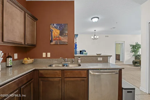 a kitchen with granite countertop a sink a stove and cabinets