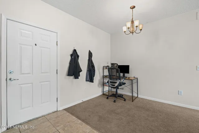 a view of a workspace with furniture and a chandelier