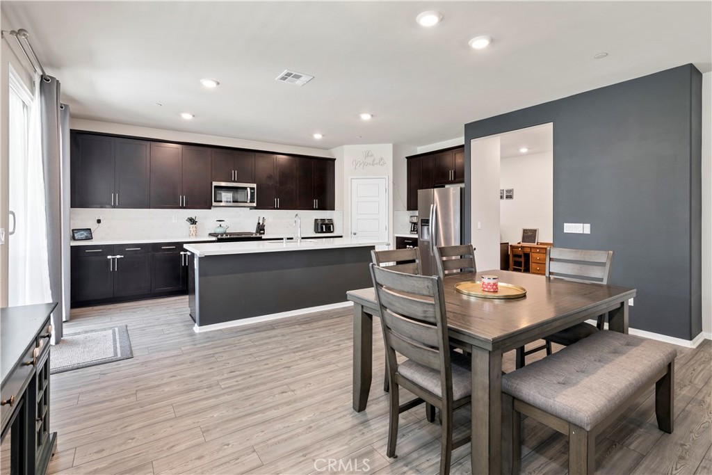 32942 Forgecroft Street Menifee, CA 92584 - Photo 11 of 44 a kitchen with stainless steel appliances kitchen island granite countertop a sink dishwasher a stove a refrigerator and island with wooden floor