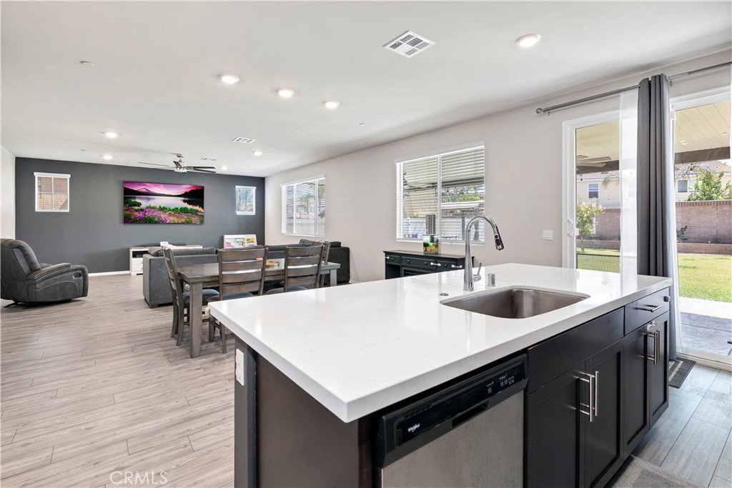 32942 Forgecroft Street Menifee, CA 92584 - Photo 12 of 44 a living room with stainless steel appliances kitchen island a large counter top and furniture