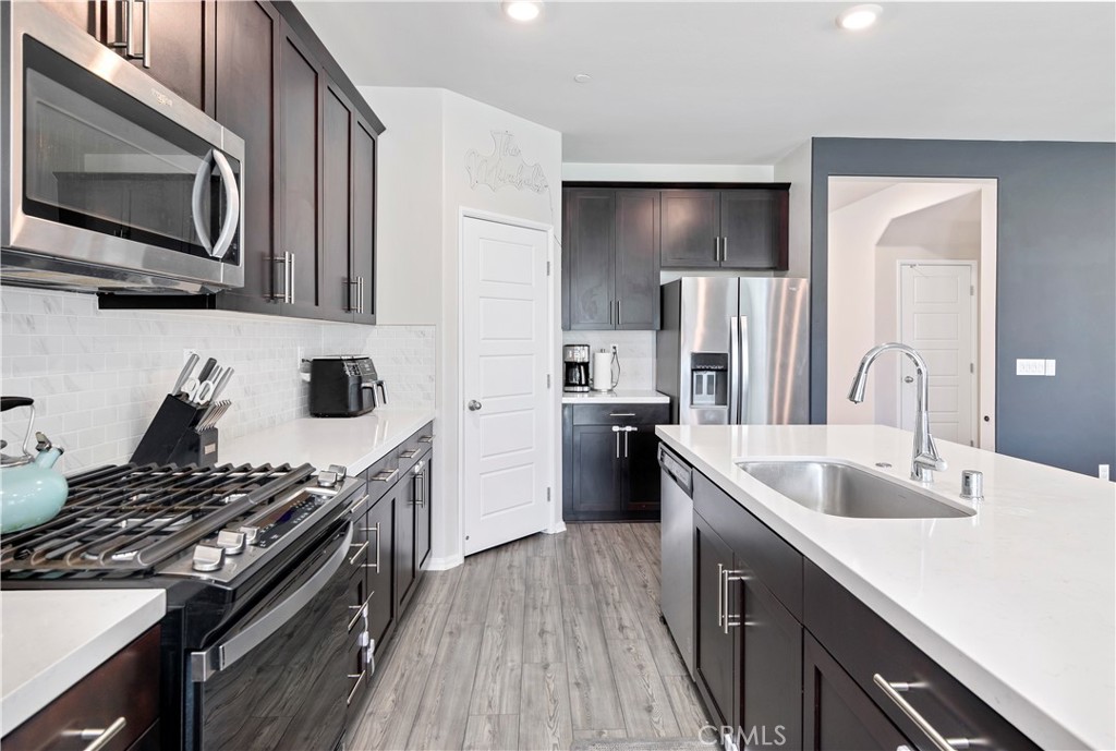 32942 Forgecroft Street Menifee, CA 92584 - Photo 14 of 44 a kitchen with stainless steel appliances a sink stove and refrigerator