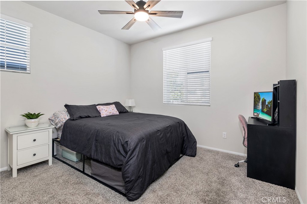 32942 Forgecroft Street Menifee, CA 92584 - Photo 20 of 44 a bedroom with a bed and a chandelier