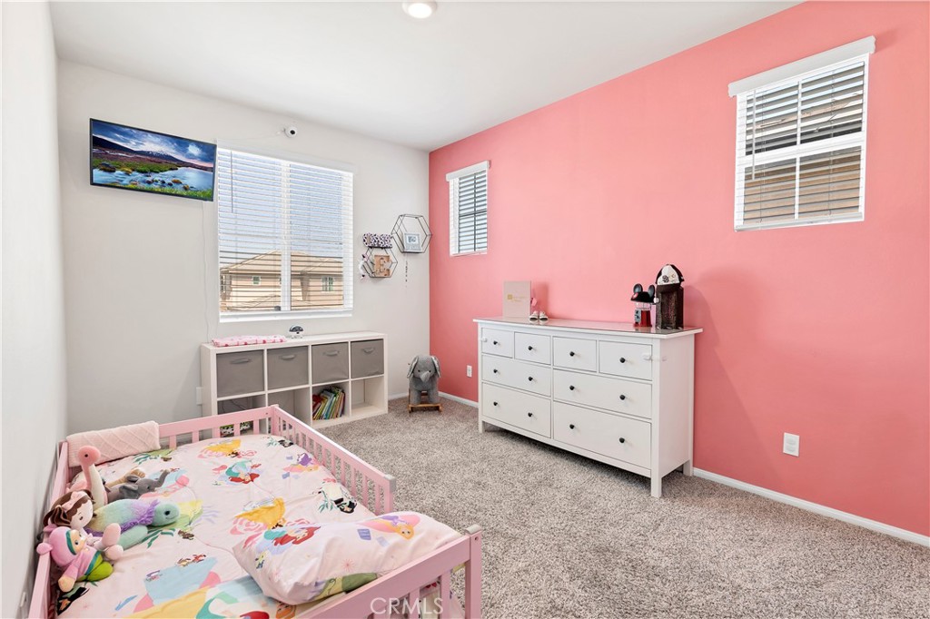 32942 Forgecroft Street Menifee, CA 92584 - Photo 24 of 44 a bedroom with a dresser and a window