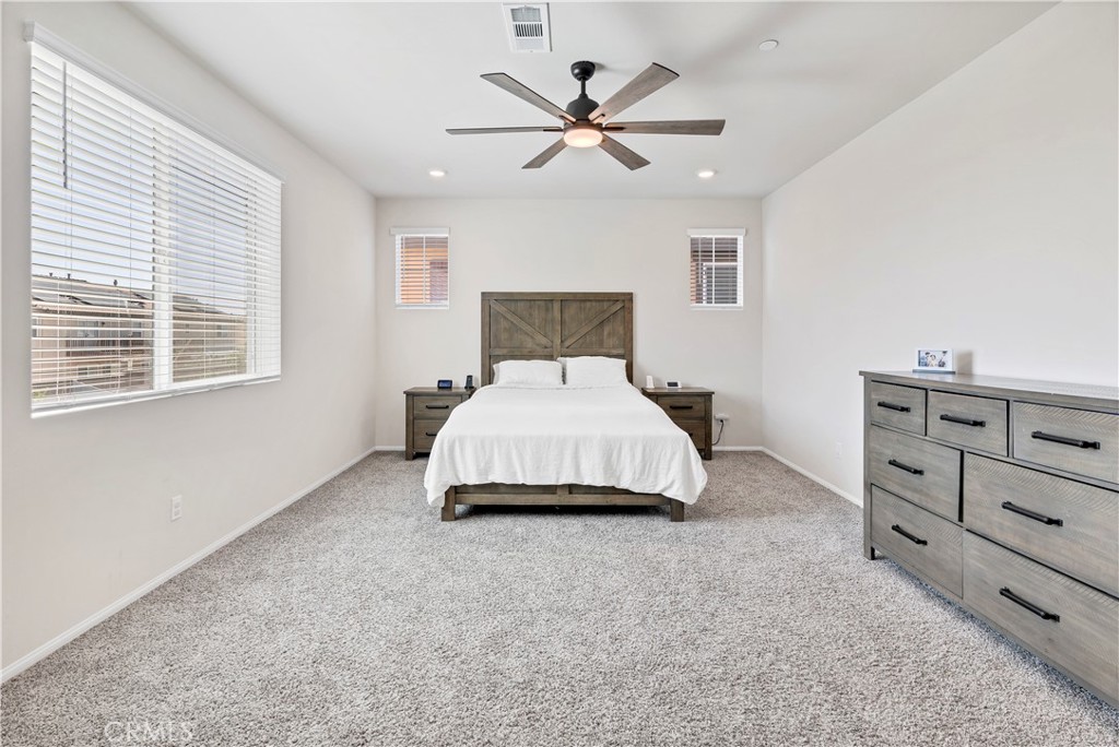 32942 Forgecroft Street Menifee, CA 92584 - Photo 27 of 44 a spacious bedroom with a bed and window