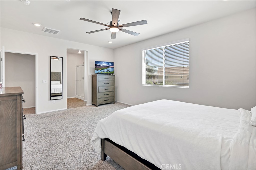 32942 Forgecroft Street Menifee, CA 92584 - Photo 28 of 44 a bedroom with a large bed and a window