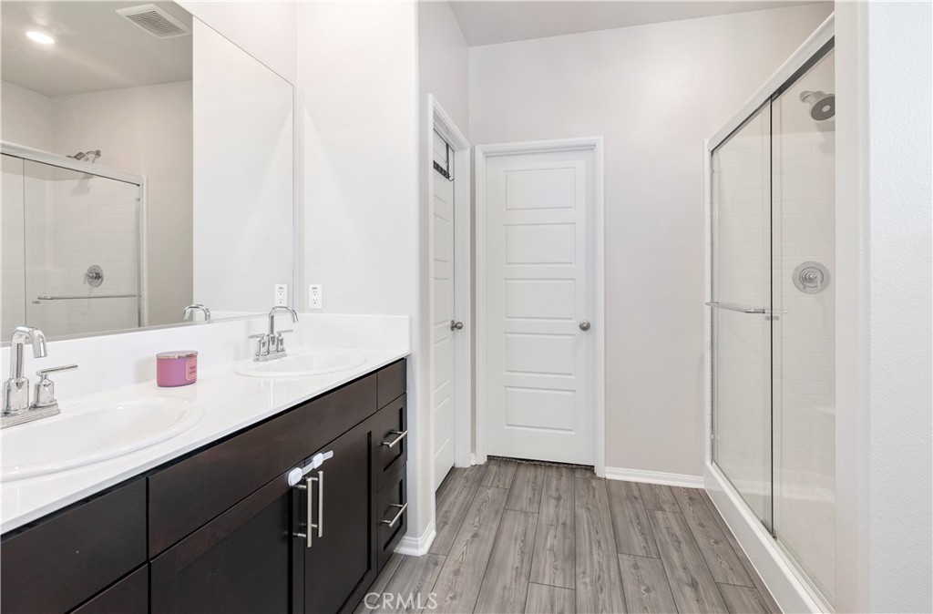 32942 Forgecroft Street Menifee, CA 92584 - Photo 29 of 44 a bathroom with a double vanity sink and mirror