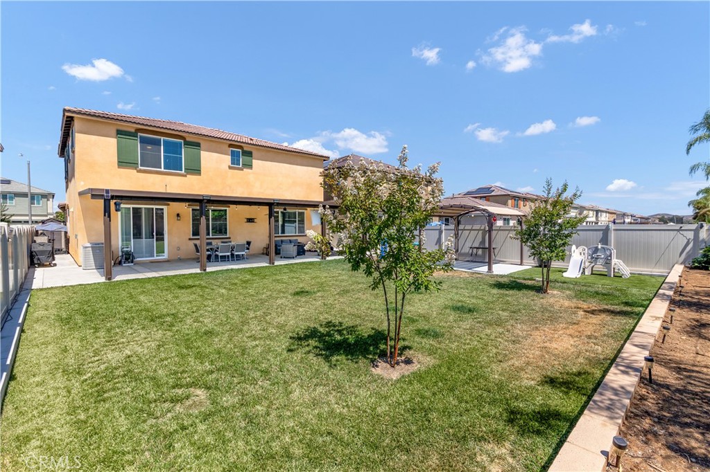 32942 Forgecroft Street Menifee, CA 92584 - Photo 35 of 44 a view of a house with a backyard and a patio