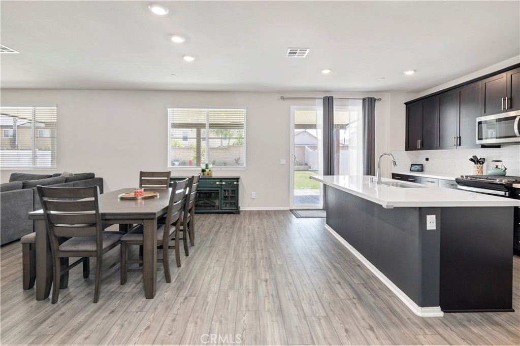 32942 Forgecroft Street Menifee, CA 92584 - Photo 8 of 44 a view of a dining room with furniture window and wooden floor