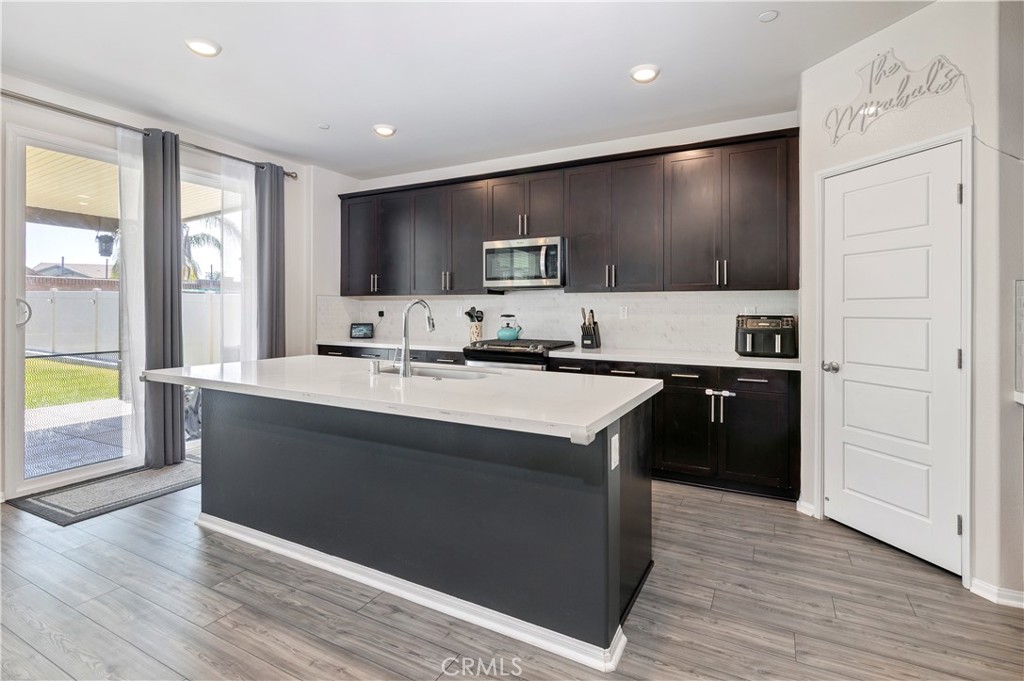 32942 Forgecroft Street Menifee, CA 92584 - Photo 9 of 44 a kitchen with kitchen island sink and stove