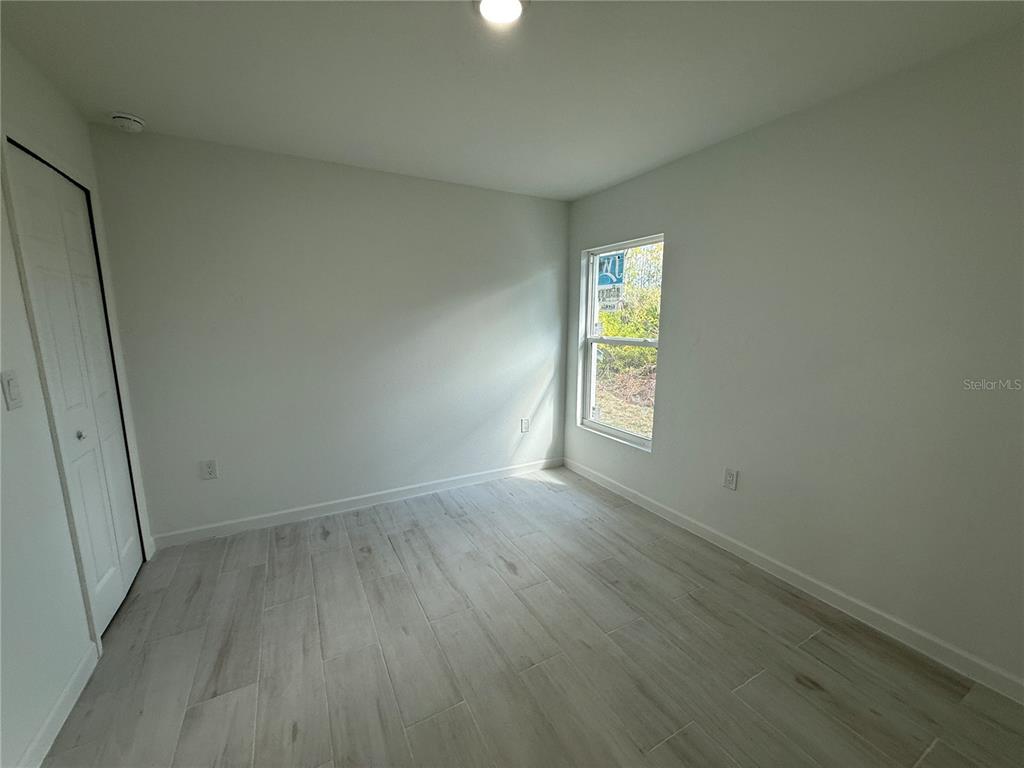 1328 Guttenburg Road North Port, FL 34288 - Photo 12 of 28 an empty room with wooden floor and windows