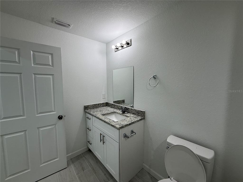 1328 Guttenburg Road North Port, FL 34288 - Photo 16 of 28 a bathroom with a granite countertop toilet and sink