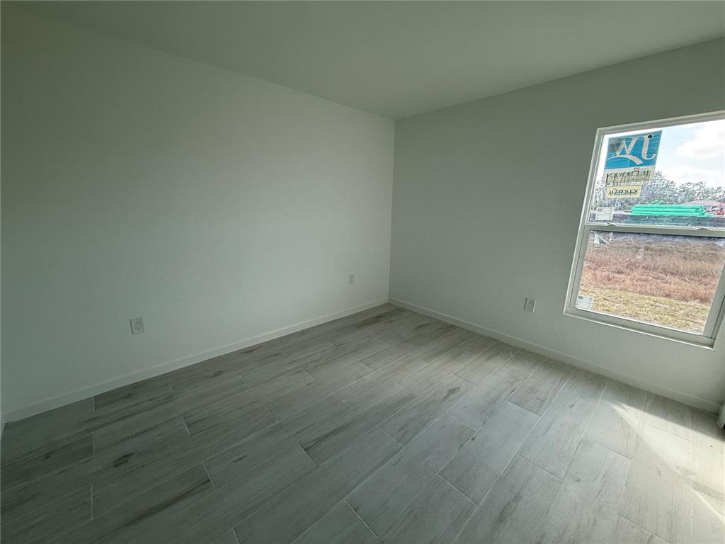 1328 Guttenburg Road North Port, FL 34288 - Photo 18 of 32 an empty room with wooden floor and windows