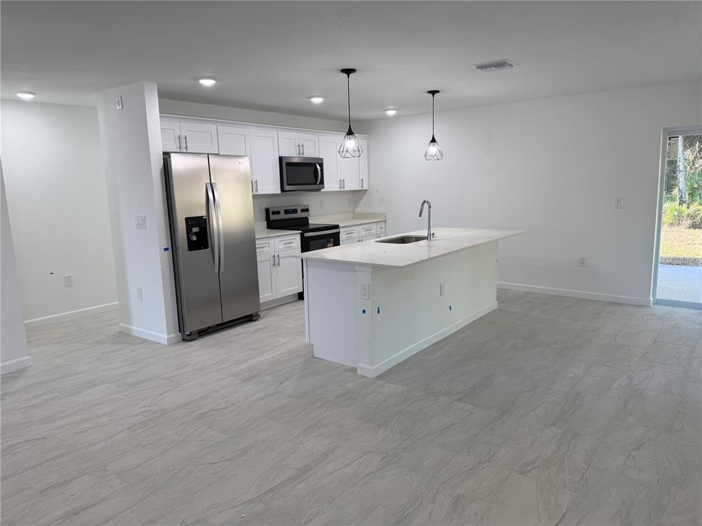 1328 Guttenburg Road North Port, FL 34288 - Photo 5 of 28 a kitchen with stainless steel appliances a refrigerator sink and microwave