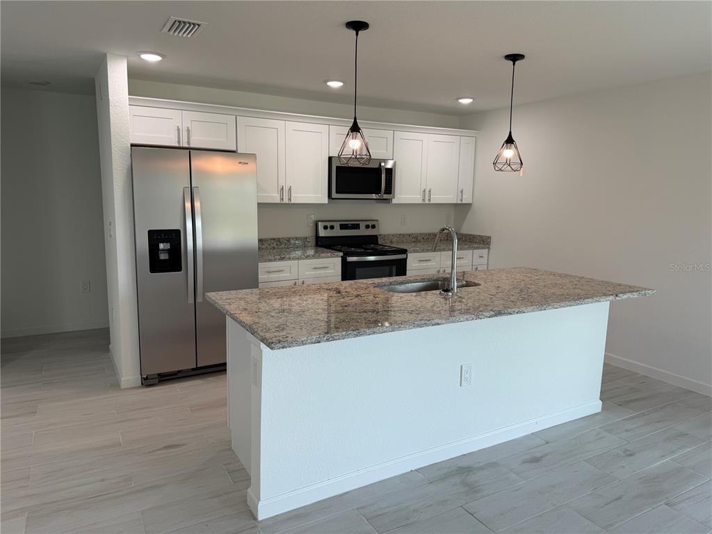 1328 Guttenburg Road North Port, FL 34288 - Photo 7 of 32 a kitchen with granite countertop a refrigerator a oven a sink and a counter top