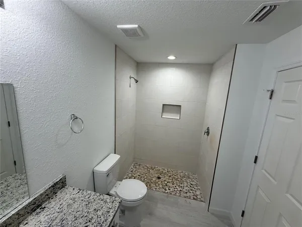 a bathroom with a sink a toilet a shower and a mirror