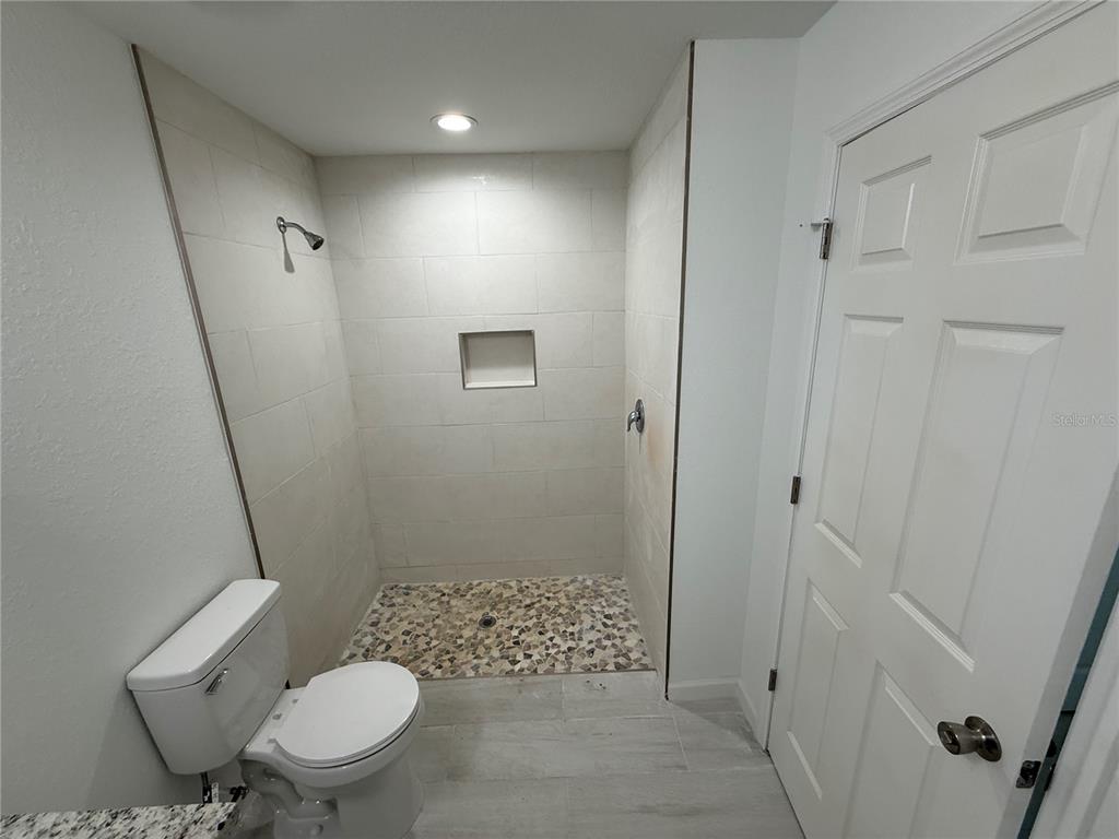 1328 Guttenburg Road North Port, FL 34288 - Photo 10 of 28 a bathroom with a granite countertop toilet a sink and a mirror