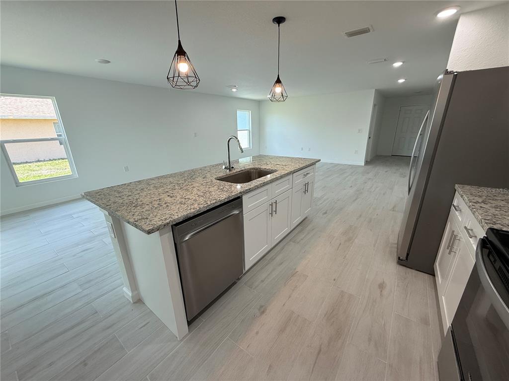 1328 Guttenburg Road North Port, FL 34288 - Photo 10 of 32 a kitchen with stainless steel appliances granite countertop a sink a stove a washer and dryer