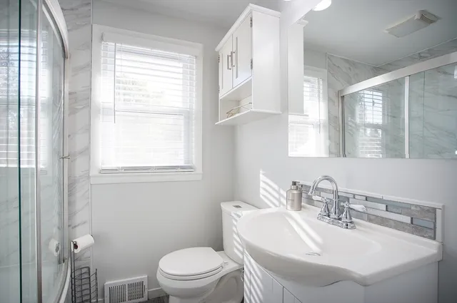 a bathroom with a sink toilet and a mirror