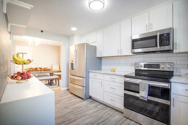 a kitchen with stainless steel appliances a stove microwave and cabinets