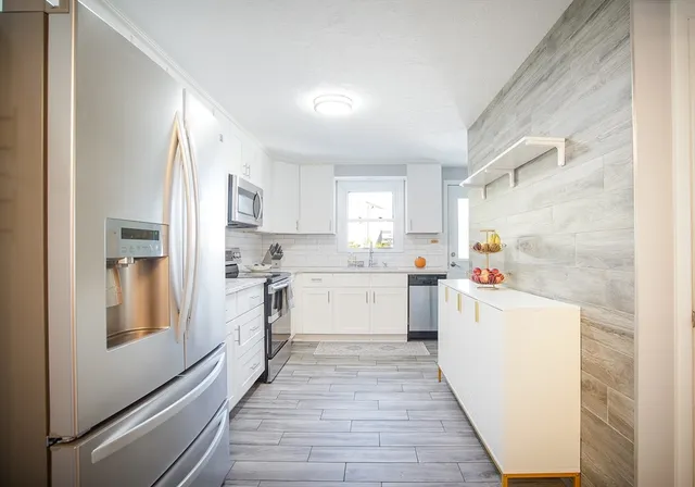 a kitchen with white cabinets and white appliances