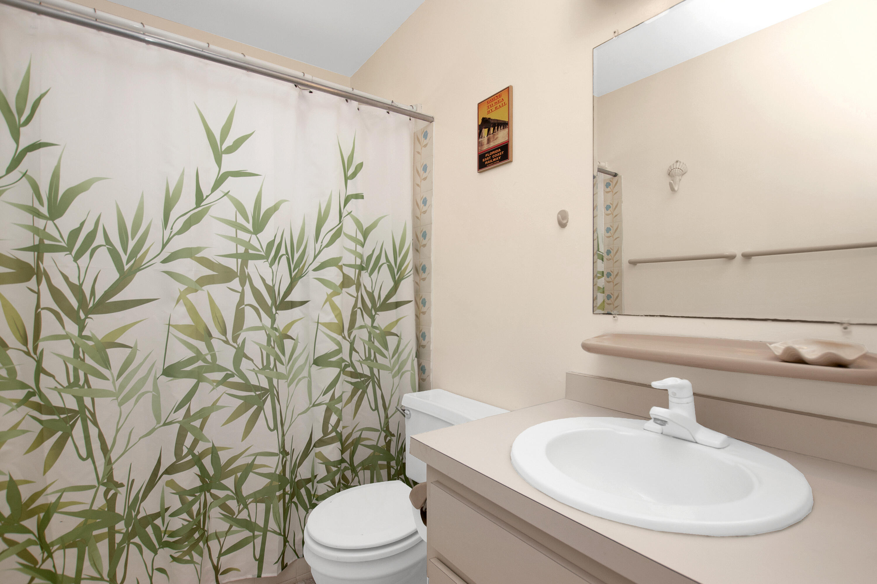 136 Brian Road Marathon, FL 33050 - Photo 17 of 19 a bathroom with a white toilet sitting next to a white sink and a shower curtain
