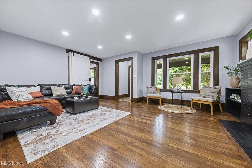 3549 Kent Road Stow, OH 44224 - Photo 8 of 44 Living area featuring wood finished floors, a fireplace with flush hearth, recessed lighting, and a barn door