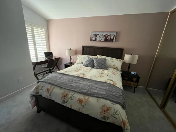 a bed sitting in a bedroom next to a window