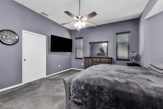 a bedroom with a bed and a flat tv screen on dresser