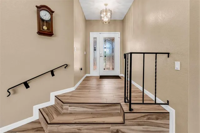 a view of a hallway with wooden floor and staircase