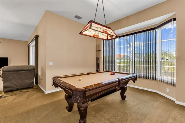a room with pool table and windows