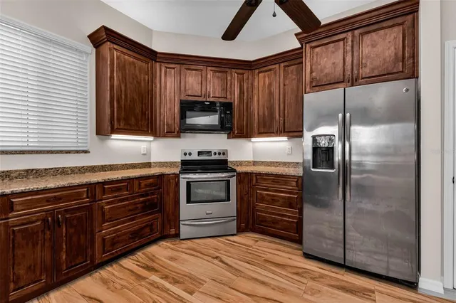 a kitchen with stainless steel appliances granite countertop a stove microwave and refrigerator