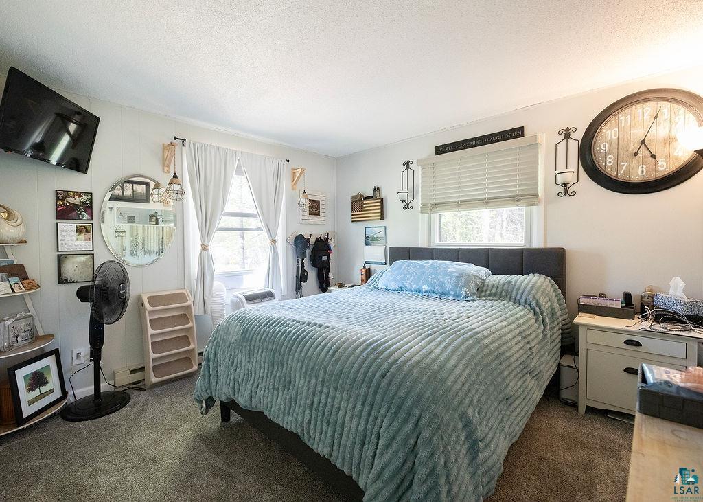 216 13th Street Proctor, MN 55810 - Photo 13 of 18 Carpeted interior with a window featuring horizontal blinds, a mounted television, and a built-in wall panel accent