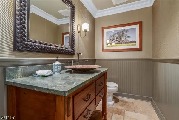 a bathroom with a granite countertop sink and a toilet