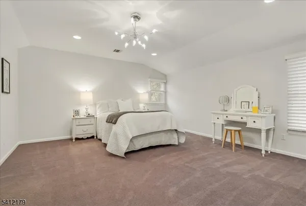 a spacious bedroom with a bed table and window
